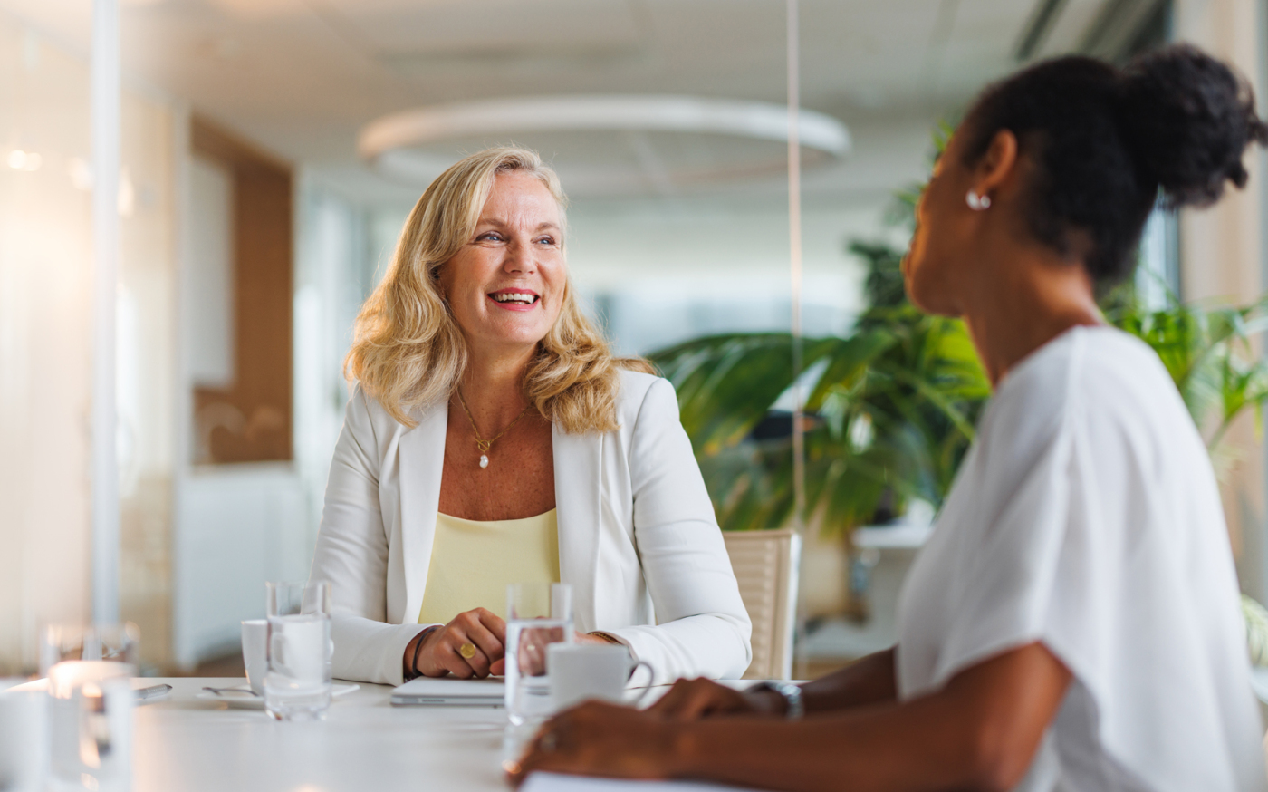 Two people sitting at a table, smiling at each other