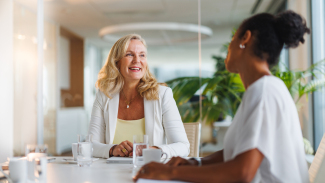 Two people sitting at a table, smiling at each other